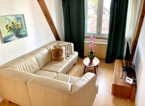 ein Wohnzimmer mit einem weißen Sofa und einem Tisch in der Unterkunft Gästehaus Casa Cecilia in Wetzikon