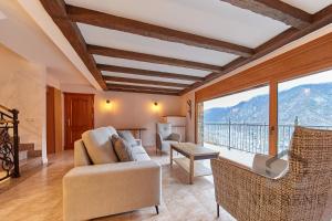 a living room with a couch and a large window at Chalet Can Noguer in Escaldes-Engordany