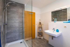 uma casa de banho com um chuveiro e um lavatório. em Ahornweg 7a em Ostseebad Karlshagen