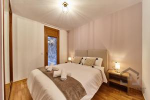 Un dormitorio con una cama grande y una ventana en Chalet Can Noguer, en Escaldes-Engordany