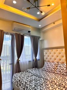 a bedroom with a bed and a large window at Deluxe Suites Razelles 2 at Shore 2 Residences Tower 1 in Manila +42 photos