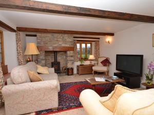 a living room with a couch and a television at 2 Bed in Wedmore 53989 in Wedmore