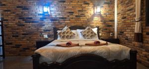 a bedroom with a bed with a brick wall at Hotel Khaosok and Spa in Khao Sok