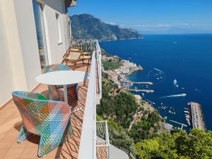 balcón con mesa y sillas y vistas al agua en Grand Hotel Excelsior, en Amalfi