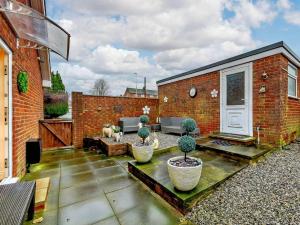 a patio with two potted plants and a building at 3 bed in Hunmanby 66717 in Hunmanby