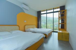 two beds in a room with a large window at Villa Ba Vi 6 Bedrooms & Pool DC Green Resort in Hanoi