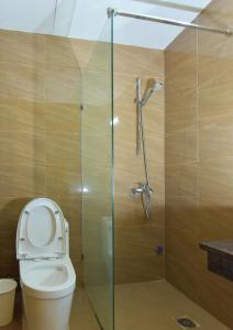 a bathroom with a toilet and a glass shower stall at Villa Ba Vi 6 Bedrooms & Pool DC Green Resort in Hanoi