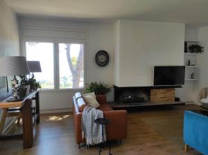 ein Wohnzimmer mit einem Sofa und einem TV in der Unterkunft Apartamento con magníficas vistas a 25 min de Barcelona in Premia de Dalt