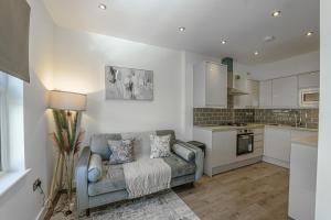 a living room with a couch and a kitchen at Stylish Homes W/ Fast Transport Links To London in Bromley