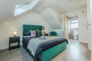a bedroom with a large bed and a bathroom at Stylish Homes W/ Fast Transport Links To London in Bromley