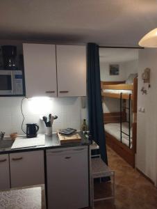 een kleine keuken met een stapelbed in een kamer bij Charmant studio avec terrasse in Praz-sur-Arly