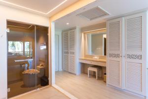 a bathroom with a shower and a sink and a mirror at The Hotspring Beach Resort & Spa - SHA Extra Plus in Natai Beach