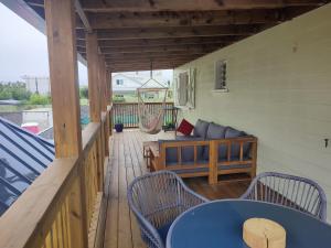 - une terrasse couverte avec un hamac, une table bleue et des chaises dans l'établissement La Belle Créole, à Cilaos