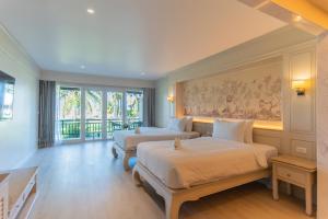 The Hotspring Beach Resort & Spa - SHA Extra Plus في شاطئ ناتاي: غرفة نوم بسريرين ونافذة كبيرة