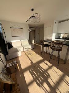 ein Wohnzimmer mit einem weißen Sofa und einem Tisch in der Unterkunft Aux roches d'Or in Roques Sur Garonne