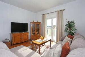 een woonkamer met een bank en een tv bij Seaview apartment Aida in Posedarje