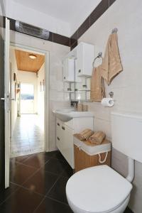 een witte badkamer met een toilet en een wastafel bij Seaview apartment Aida in Posedarje