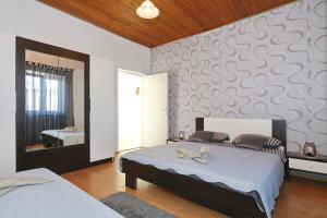 een slaapkamer met 2 bedden en een muur bij Seaview apartment Aida in Posedarje