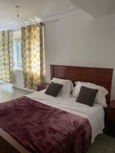 a bedroom with a large bed with two pillows at Ingrid's Place - Namugongo in Namugongo