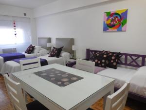 a living room with white furniture and a table and chairs at Studio en Microcentro in Buenos Aires