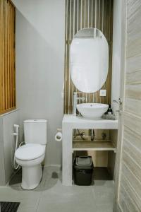 a bathroom with a white toilet and a sink at Bingin Garden Uluwatu in Uluwatu