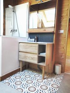 ein Bad mit einem Waschbecken und einem Spiegel in der Unterkunft WhispeRive Lodge - le vert aux bords de rive in Le Bourg-dʼOisans