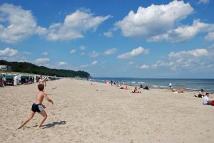 Ein kleiner Junge, der mit einem Frisbee am Strand spielt. in der Unterkunft Ferienwohnung zur Baaber Heide in Baabe