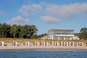 eine Gruppe von Stühlen am Strand mit einem Gebäude in der Unterkunft Ferienwohnung zur Baaber Heide in Baabe