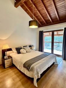 ein Schlafzimmer mit einem großen Bett und einem großen Fenster in der Unterkunft Spacious penthouse chalet apartment in Pirin Golf and Country Club in Raslog