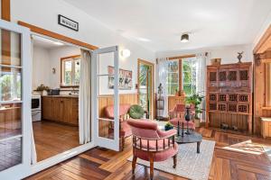 a living room with a table and chairs and a kitchen at Aranui palms - Mapua Holiday Home in Mapua