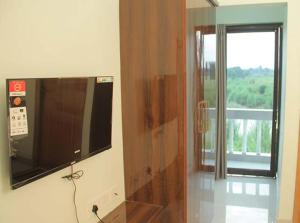 a room with a television on a wall with a window at Bishnupur River Side Resort in Vishnupur