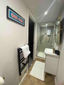 a bathroom with a white sink and a shower at Boutique, weaver’s cottage. Views in Bradford on Avon