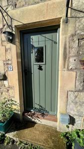 a glass door in a stone building with at Boutique, weaver’s cottage. Views in Bradford on Avon