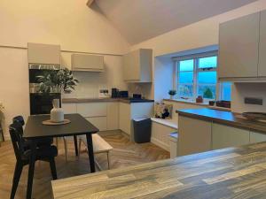 a kitchen with a table and a dining room at Boutique, weaver’s cottage. Views in Bradford on Avon