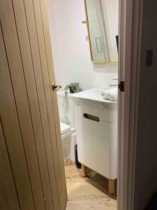 a bathroom with a white sink and a toilet at Boutique, weaver’s cottage. Views in Bradford on Avon +15 photos