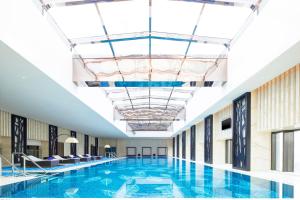 a large swimming pool in a building with a ceiling at Sheraton Changde Wuling Hotel in Changde