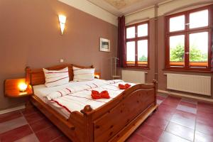 1 dormitorio con 1 cama grande con arcos rojos. en Villa Maria Wohnung 02 en Ostseebad Koserow
