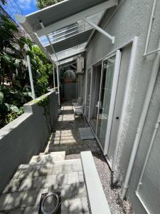 a walkway leading to a house with a patio at Spacious basement studio in tranquil nook in Rivière Noire