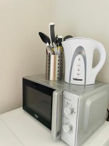 un horno microondas con jarra blanca y utensilios de cocina en Monteurzimmer in Kevelaer en Kevelaer