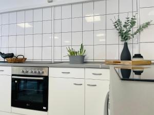 uma cozinha com armários brancos e um forno preto em Monteurzimmer in Kevelaer em Kevelaer