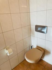 a toilet in a bathroom with a toilet paper dispenser at Monteurzimmer in Kevelaer in Kevelaer