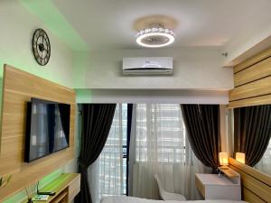 a room with a bed and a tv and a window at Woodland Elegance Retreat Symphony of Artistry with Blazing fast 300 Mbps in Manila