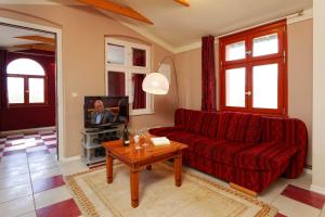 salon z czerwoną kanapą i telewizorem w obiekcie Villa Maria Wohnung 09 w Koserowie