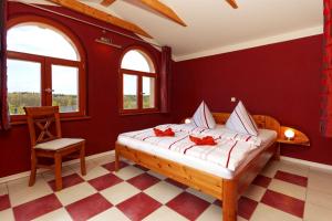 オストゼーバート・コゼロウにあるVilla Maria Wohnung 09の赤い壁のベッド1台と椅子が備わるベッドルーム1室が備わります。