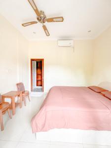 sypialnia z łóżkiem i wentylatorem sufitowym w obiekcie Ojek's Homestay w mieście Ubud