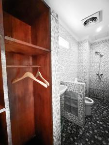 a bathroom with a wooden door with a sink and a toilet at Ojek's Homestay in Ubud +67 photos