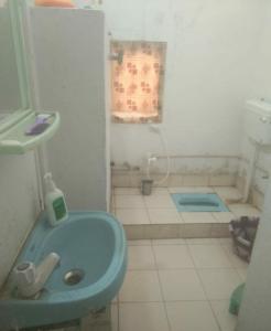 a bathroom with a blue sink and a shower at Mannat Rooms in Allahābād