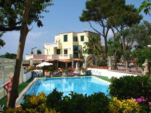 a large swimming pool in front of a resort at Albergo Villa Hibiscus in Ischia