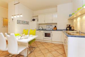 ツィノヴィッツにあるBlaue Laguneのキッチン(白いテーブル、黄色い椅子付)