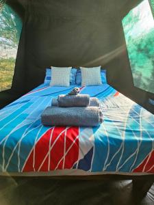 a bed in a tent with some towels on it at Merry Mongoose Riverside Tent in Skeerpoort